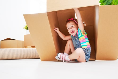 child playing with packing box and involved with the move to Massachusetts