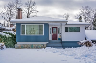 Blue house in Massachusetts with snow in front yard