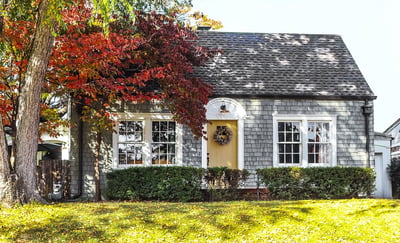 Grey wooded shingle Cape-style home. 