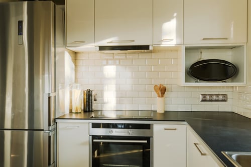 Kitchen with white subway tiles for backsplash and stainless steel appliances. 