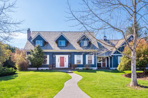 blue house with white shutters and dormers. 