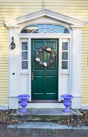 green door to an entrance with purple planters