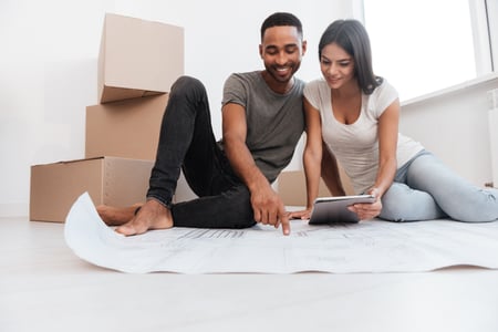 Couple planning how to layout furniture in their new home