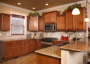 Kitchen in home with brown cabinets and granite countertops