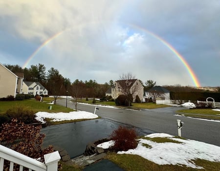 Rainbow in nice neighborhood with snow on the ground